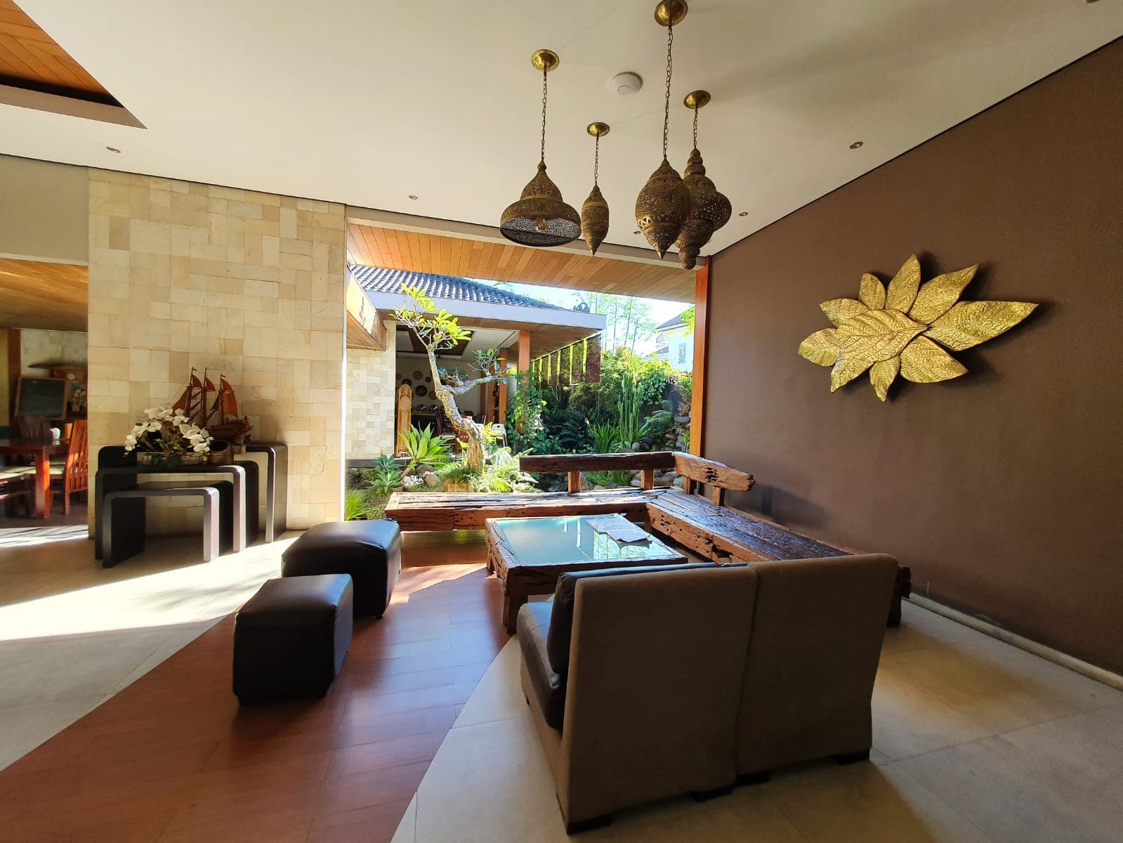 Lounge area dengan ornamen kuningan dan furnitur kayu vintage